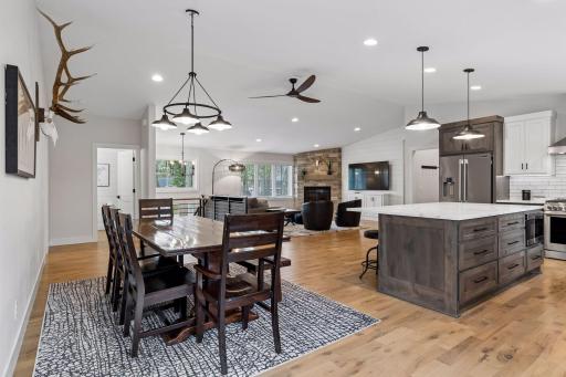 Open floorplan with custom cabinets, hardwood floors, vaulted ceiling and fireplace,
