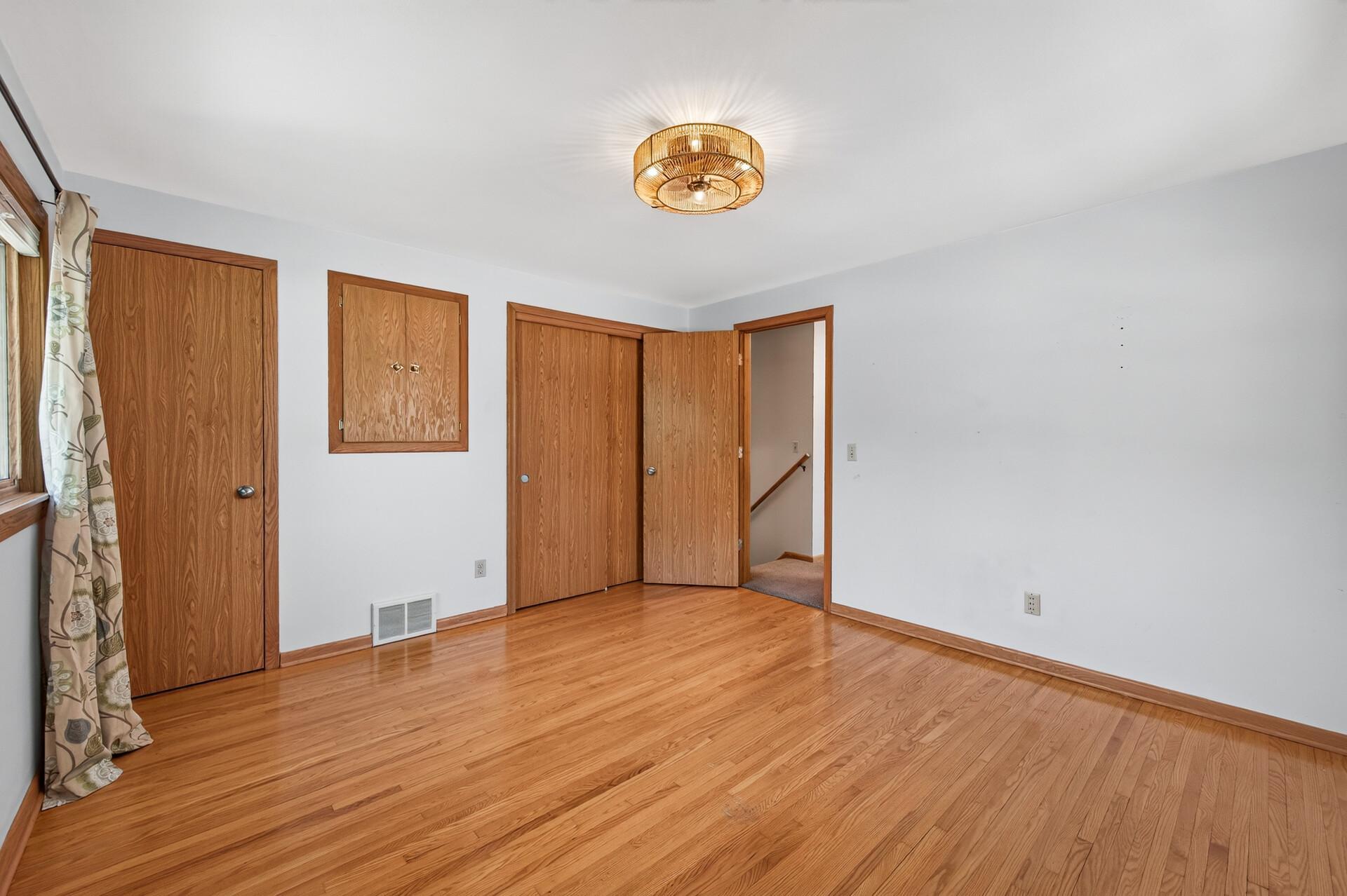The spacious primary bedroom features hardwood floors and generous closet space.