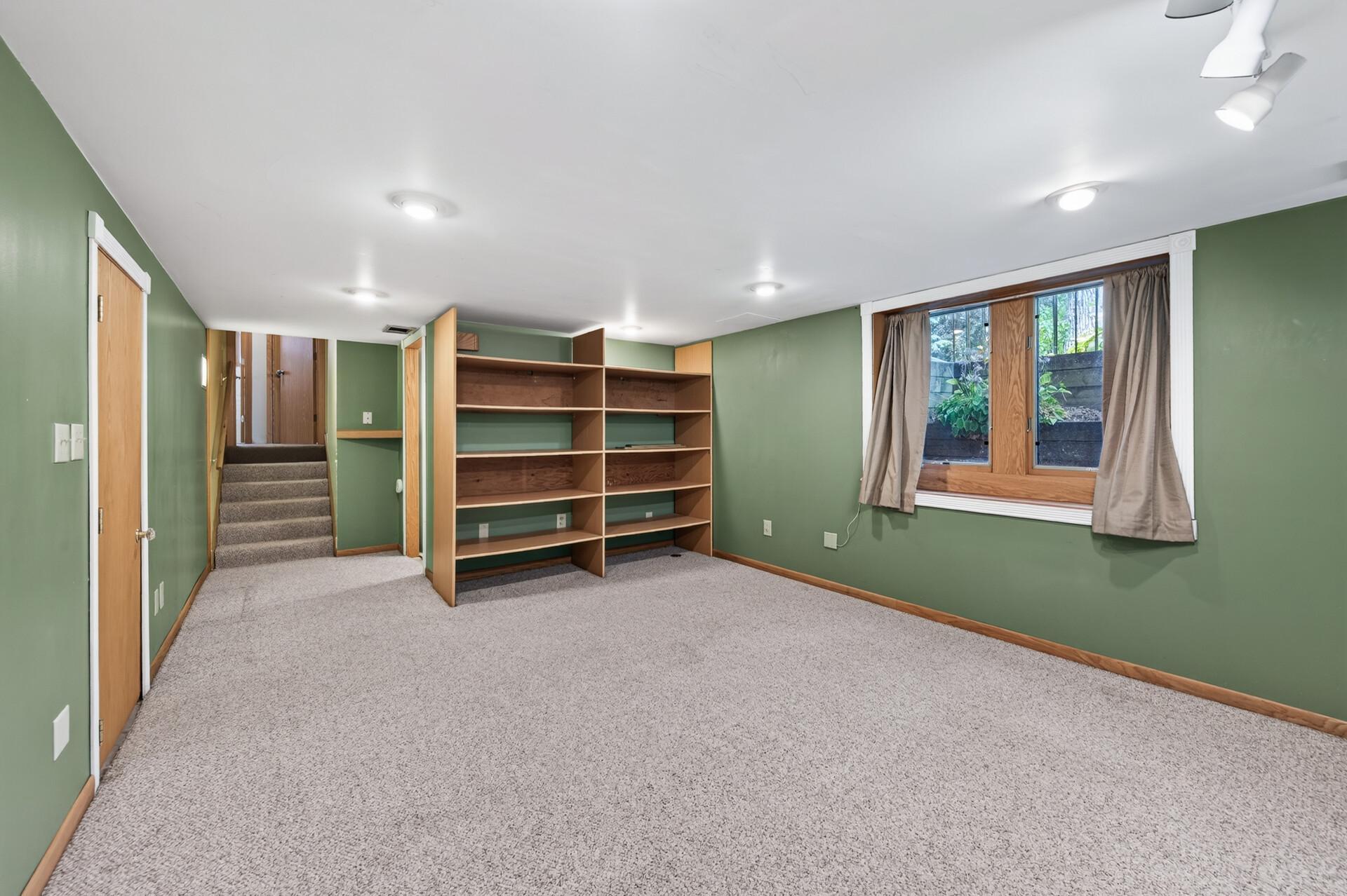 Built-in shelving adds both character and practical storage to this versatile lower-level living space.