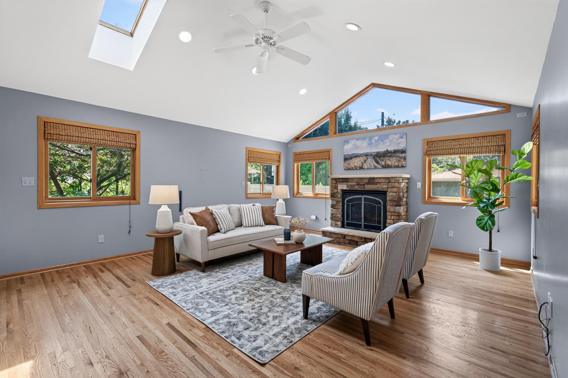 Vaulted ceilings, skylights, and a stunning stone fireplace create a bright and welcoming great room.