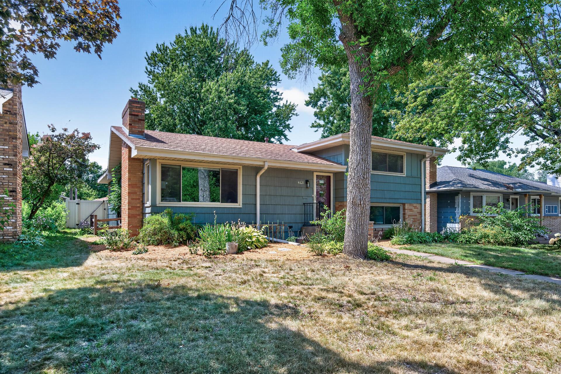 Attractive landscaping and mature trees add to the home's welcoming curb appeal.