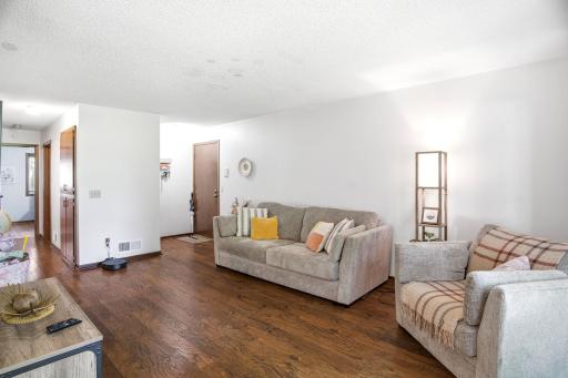 Alternate view of the living room showing the open layout and front entry access.