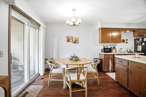 Dining space with updated light fixture, sliding glass door, and views of the backyard green space.