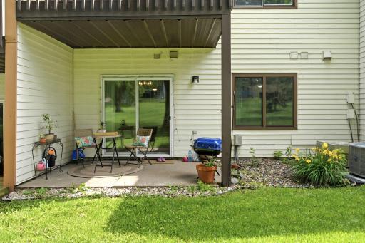 Private covered patio with space for outdoor seating and direct access to the shared green space.