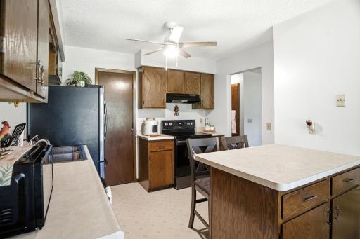 Kitchen featuring abundant cabinet storage, center island with seating, and adjacent dining area.