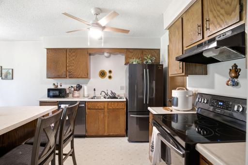 Additional kitchen perspective highlighting the island, work surfaces, and dining space.