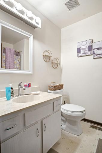 bathroom featuring an updated vanity, modern lighting, and tub/shower combination.