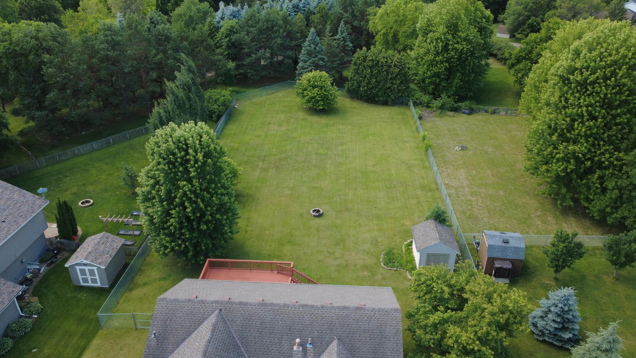 Aerial of giant fenced in backyard including storage shed.
