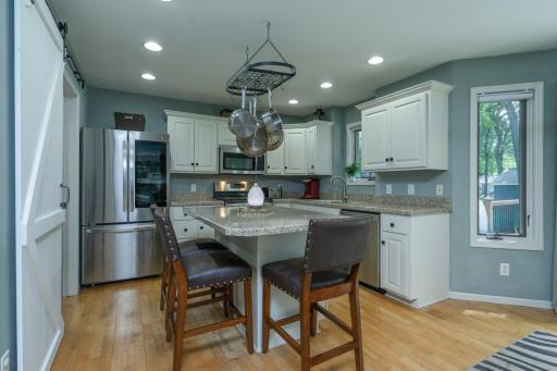 The heart of the home features abundant cabinetry, granite countertops, and a spacious center island with seating.