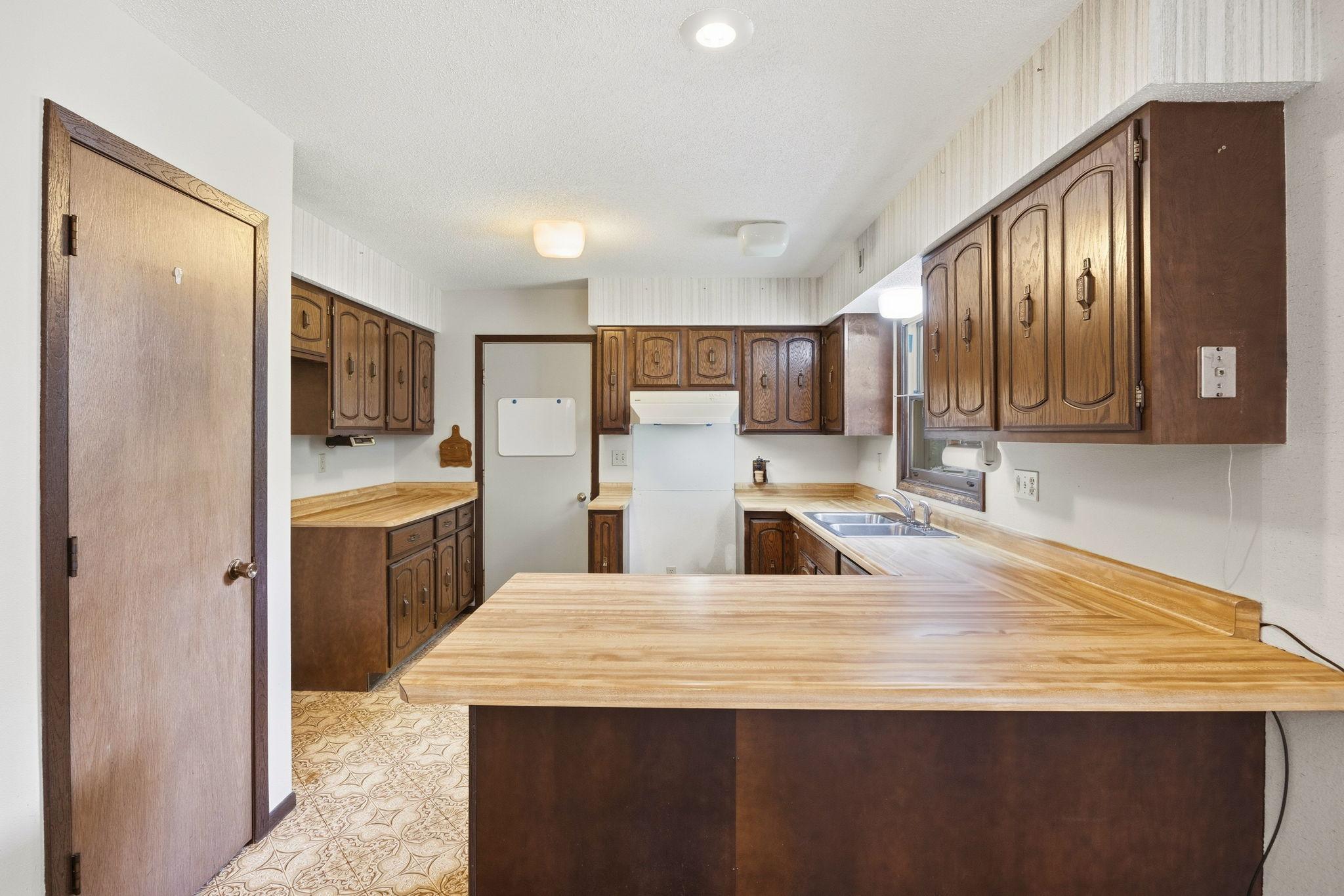 Functional kitchen featuring abundant cabinetry, generous counter space, and a convenient breakfast bar for everyday dining.
