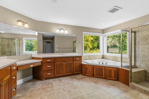 Spacious bathroom with a separate water closet, walk in shower and a corner soaking tub