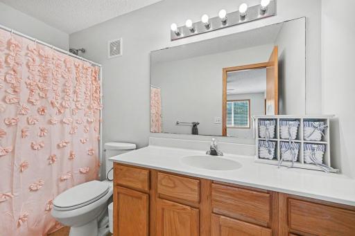 Upper-level full bathroom with vanity storage, tub:shower combination, and bright neutral finishes..jpg