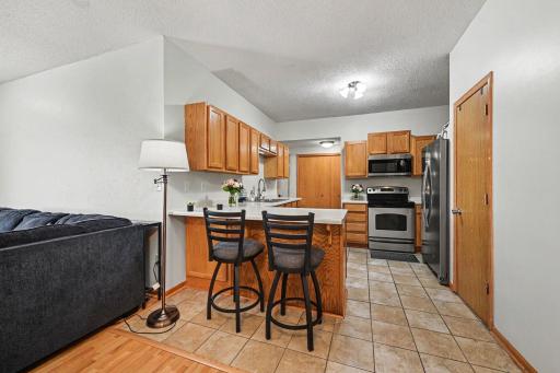Functional Chaska twin home kitchen with stainless steel appliances, wood cabinetry, and breakfast bar seating..jpg