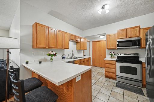 Kitchen with breakfast bar peninsula, stainless steel appliances, and open connection to the main living area..jpg