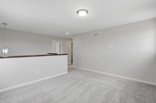 Spacious upper-level loft offers flexible living space for an office or study area.