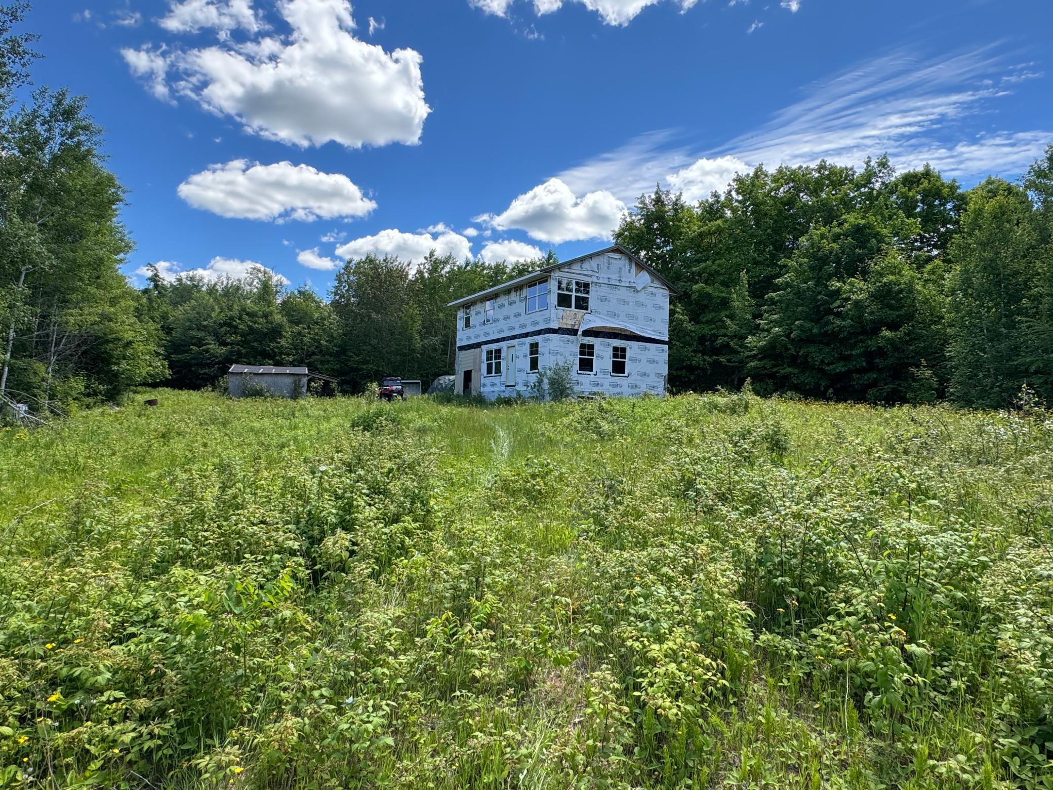 The bunk house sits in a small open field. The remainder of the property is wooded.