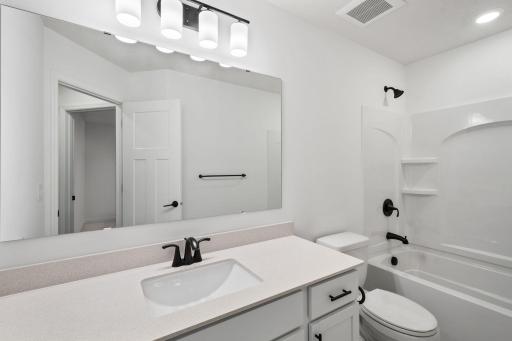 This full second-floor bathroom features a wide single vanity and shower-tub combination.