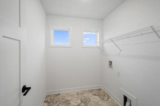 The laundry room features washer and dryer hook-ups and shelving for storage.