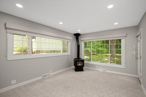 Family room addition has wall of windows and a freestanding wood stove (never used)