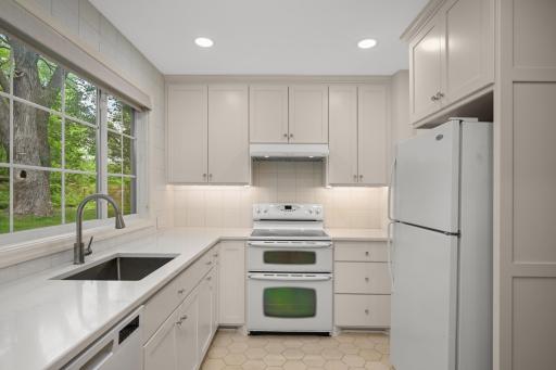 Quartzite countertops and white tiled backsplash.