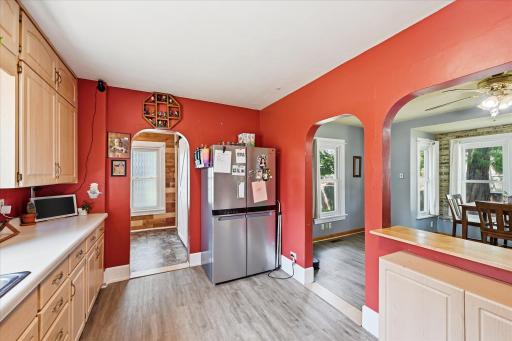 Open entry into the kitchen and newer stainless refrigerator.