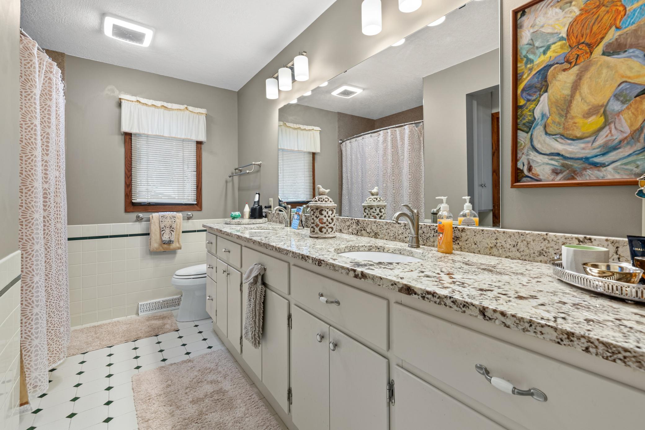 full bathroom with double vanity in main floor bathroom
