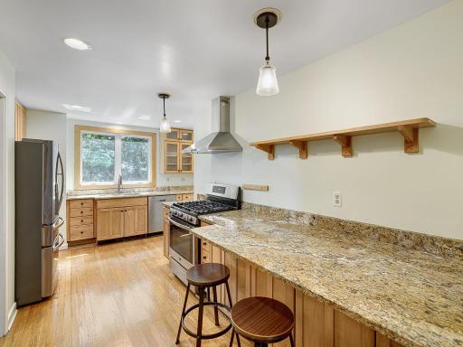 The updated kitchen features a breakfast bar and plenty of counter space and cabinetry