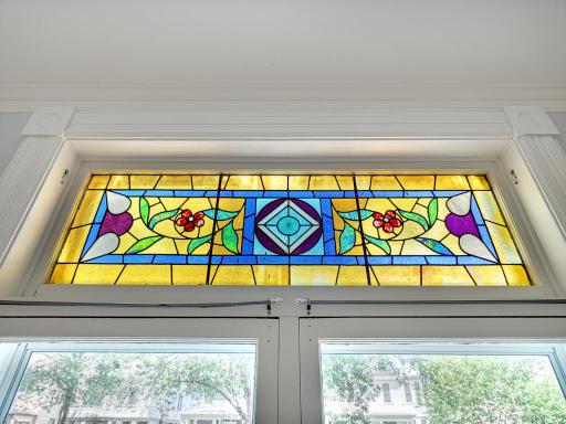 A Beautiful stained glass window details the living room