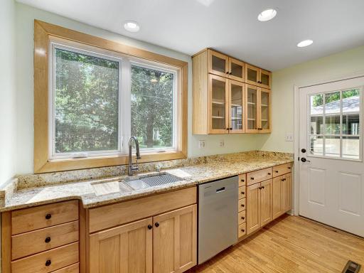 A large window over looks the backyard above the custom sink. The kitchen walks out to the deck