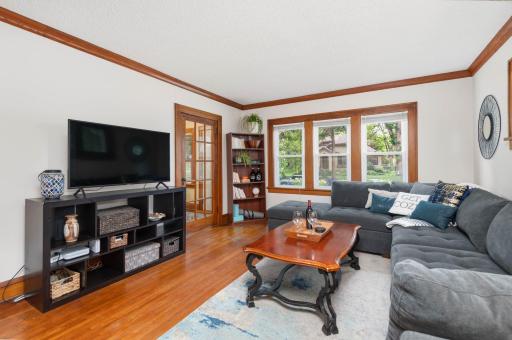 Sun-drenched Living Room with hardwood floors & crown moulding