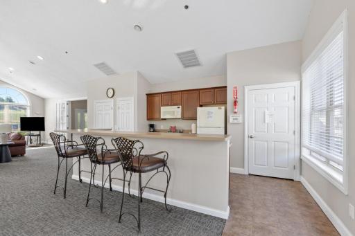 Clubhouse kitchen features a wide raised breakfast bar with barstool seating, perfect for hosting social groups, holiday events, or just hanging out with your friendly neighbors year-round!