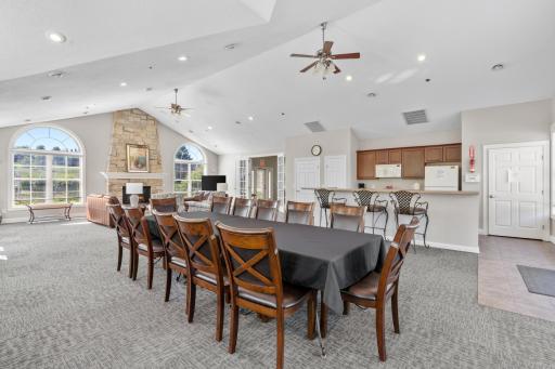Grand community clubhouse banquet room featuring an expansive dining layout, vaulted ceilings, and a fully equipped kitchen setup!