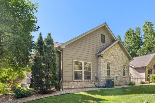 Beautiful end-unit exterior view highlighting the premium stone craftsmanship and the exceptional side yard privacy!