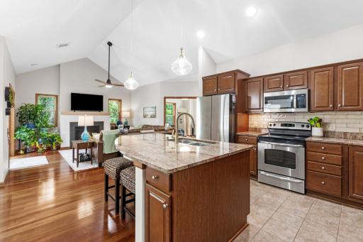 Chef's kitchen boasting premium stainless appliances, tile backsplash, with undermount cabinet lighting, and a brand-new sleek faucet and soap dispenser set installed for absolute turn-key convenience!