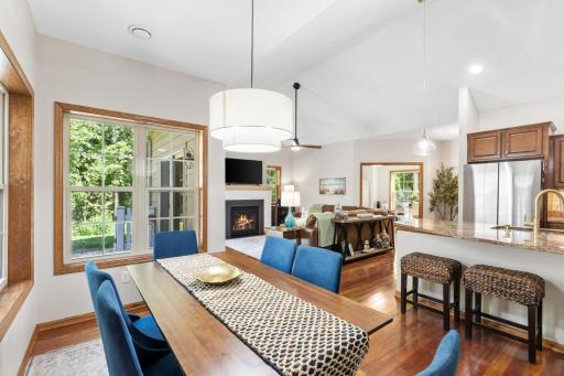Dedicated dining space wrapped in large windows with scenic wooded views, highlighted by an all-new modern statement light fixture and fresh contemporary paint!