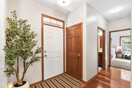 Bright front entry foyer welcoming you with a spacious coat closet, gorgeous wood floors, fresh contemporary paint, and a clear layout leading straight to the private guest wing!