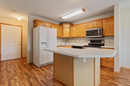 Kitchen is open to living room & dining room with natural light from patio door