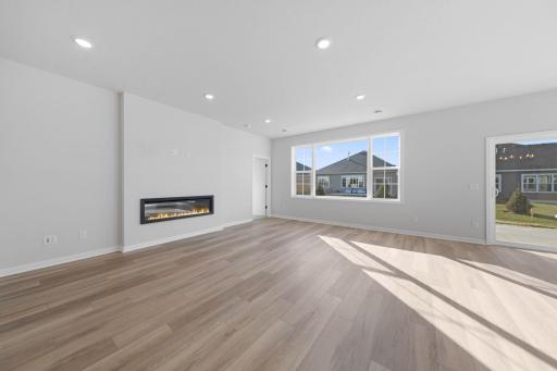 Representational Purpose Only. Living Room features LVP flooring and fireplace- check out the oversized windows!