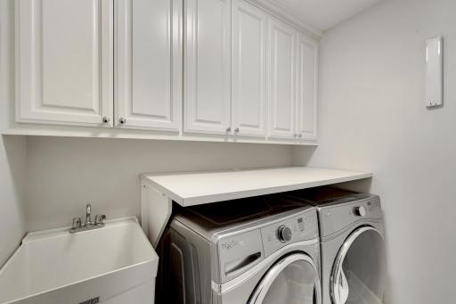 Upstairs laundry room with cabinets, sink and countertops!