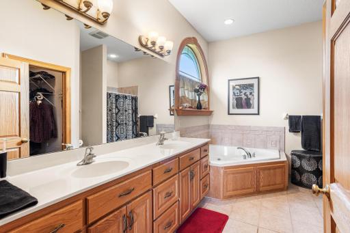 The primary bathroom includes a dual-sink vanity, soaking tub, separate walk-in shower, and linen storage.