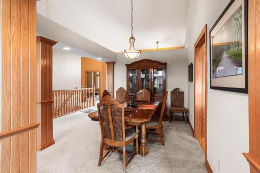 The formal dining room offers ample space for hosting holiday meals and special occasions beneath a stylish hanging light fixture.
