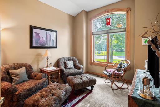 Just off the foyer, the front bedroom currently used as a sitting room. This room offers flexible space for a formal living room, music room, library, or home office, enhanced by a large arched window and soaring ceilings.