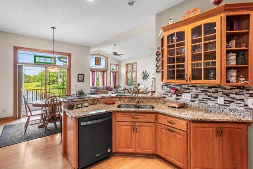 The kitchen sink overlooks the informal dining area, deck access, and the adjoining living room, enhancing the home's open layout.