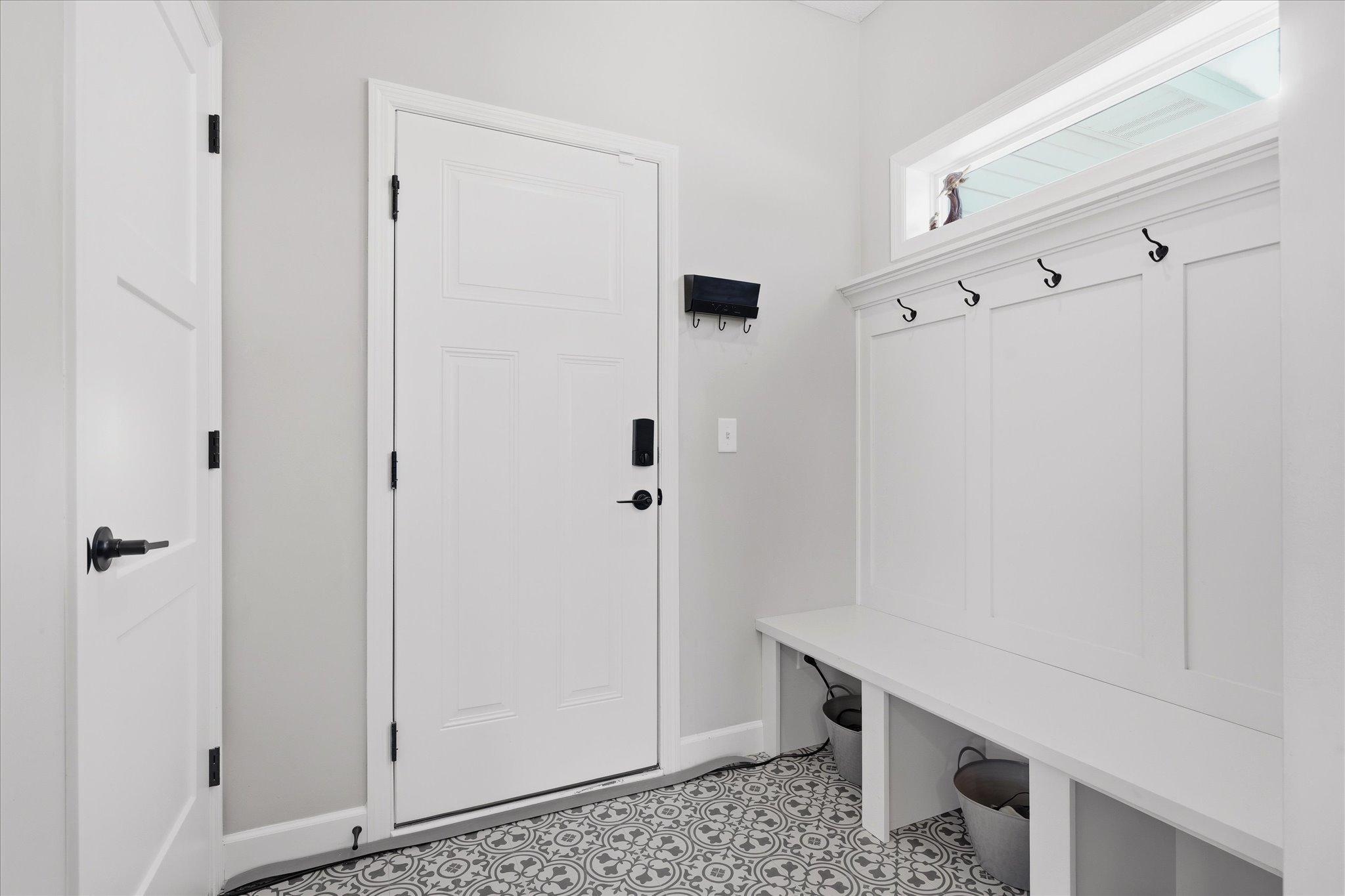 Fantastic mudroom between garage and kitchen with built-in bench and hooks plus large walk-in closet