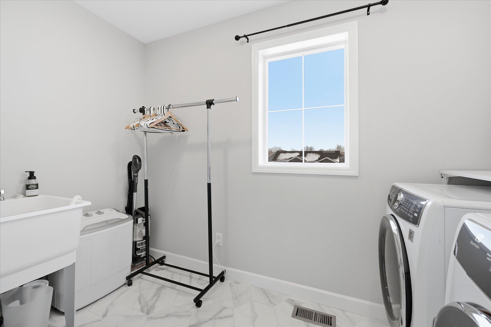 Upper Level large laundry room with shelf and sink