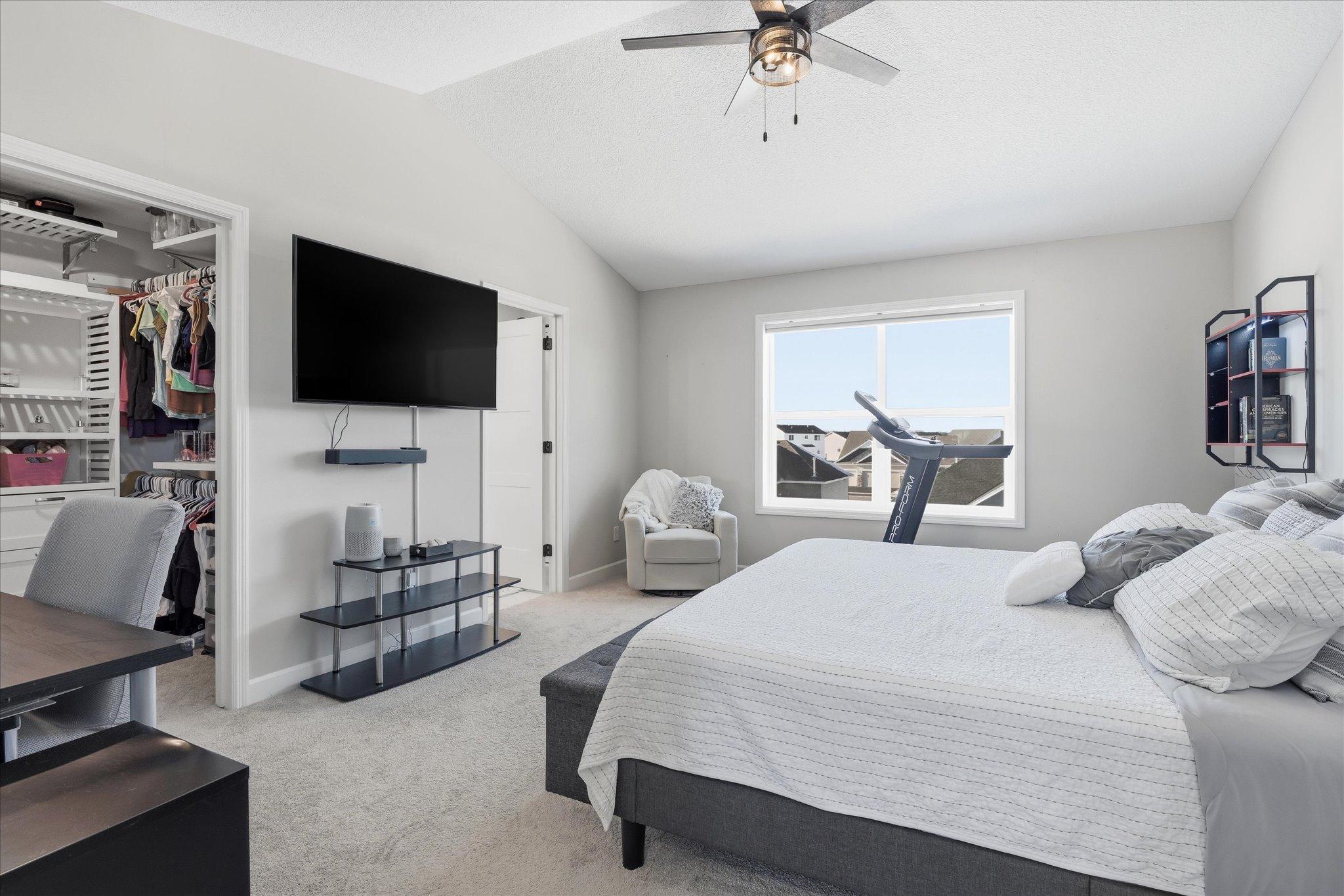 Vaulted primary suite stuns with walk-in closet with builtins and a spa-like bathroom