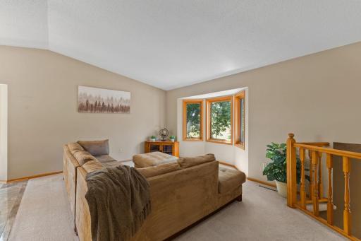 At the top of the stairs, you'll note the vaulted ceilings and living room area with a bay window.