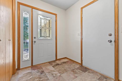 The generously-sized foyer features neutral marble tile floors.