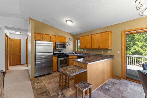 The kitchen features wood cabinetry, stainless steel appliances, and a special mini-table extension with 3 matching mini stools.