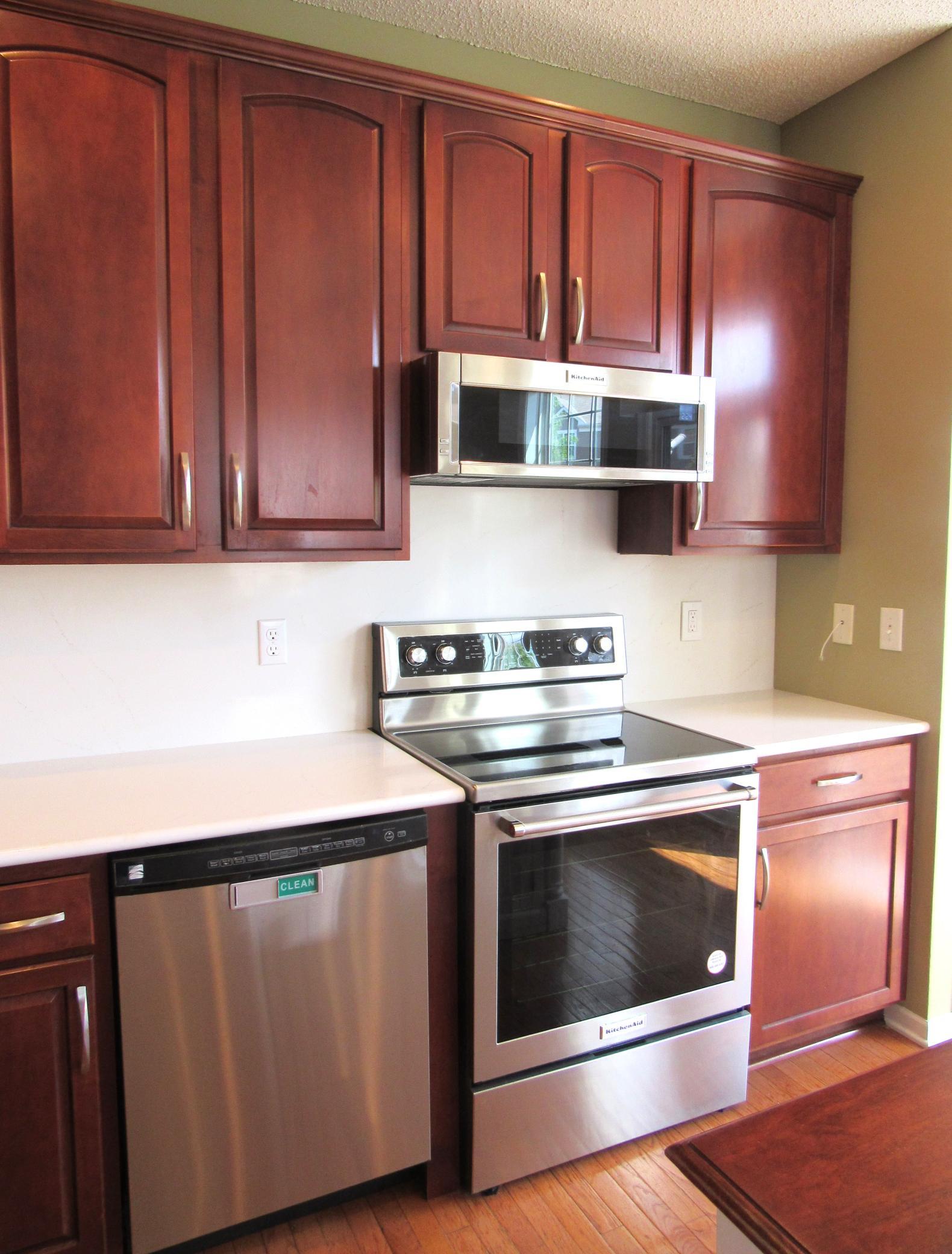 The kitchen was updated in 2024 with new quartz counter tops, quartz backsplash, farm sink, Kitchenaid stove and microwave. There is a Kenmore dishwasher and stainless steel refrigerator and a disposal.